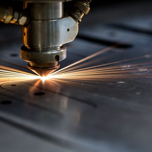 Laser cutting metal with sparks flying in an industrial setting